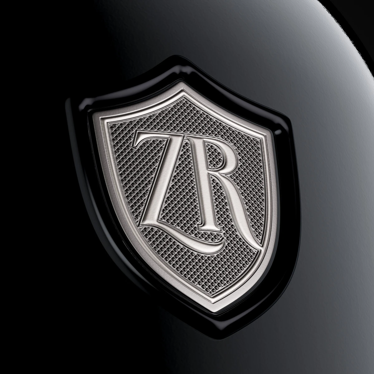 Macro of the pewter ZR monogram shield with micro-embossed semi-matte texture and a thick black resin frame on a dark sparkling wine bottle