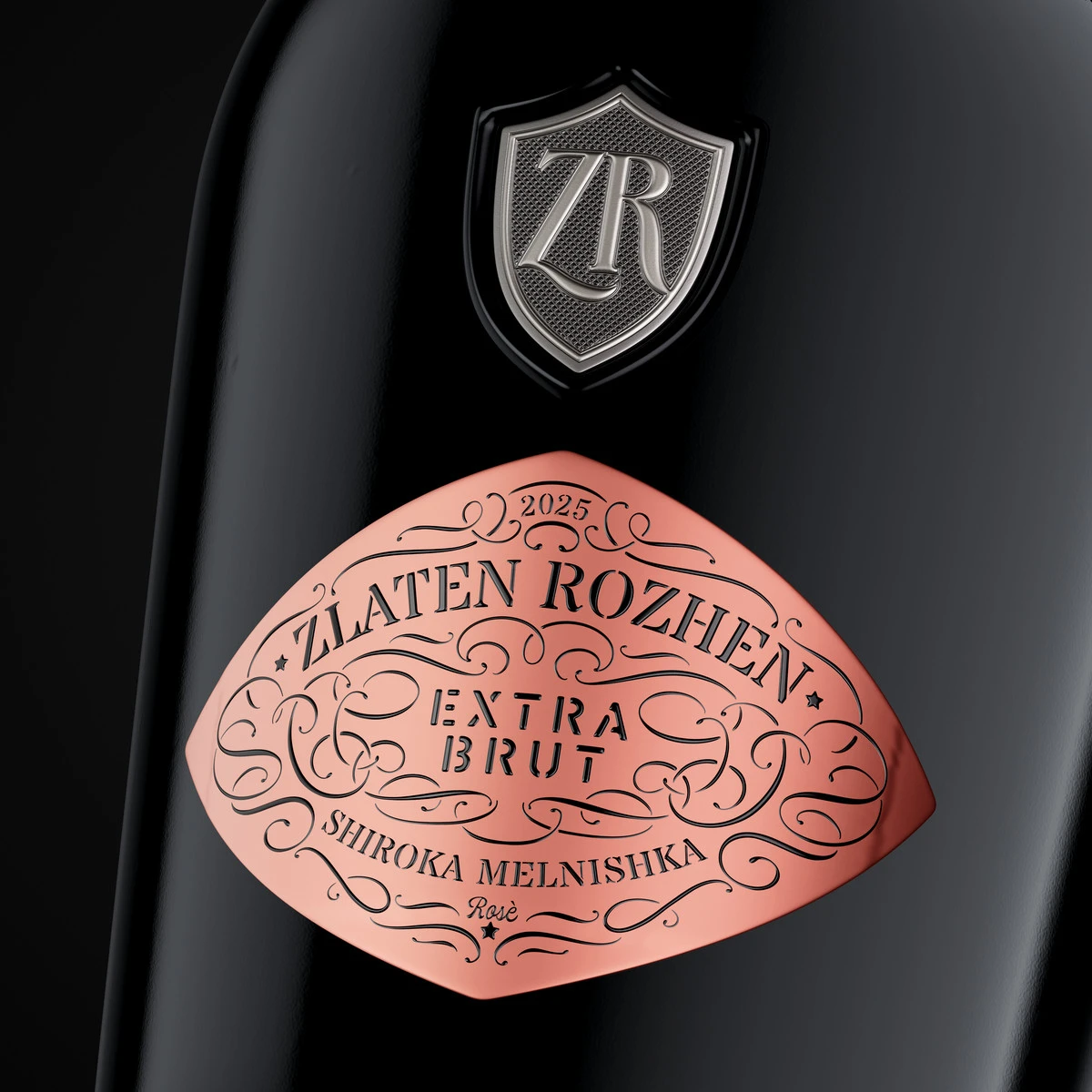 Close-up of the Zlaten Rozhen Extra Brut Rosé diamond label printed on pink soft-touch metallic foil, with the ornamental frame and the pewter ZR shield above
